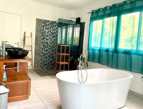 uma grande casa de banho com banheira e lavatório em Kaz Ajeya em Les Avirons