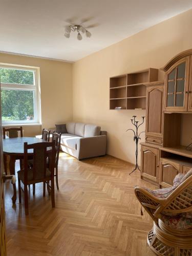 een woonkamer met een tafel en een bank bij Cozy two-room apartment in Druskininkai