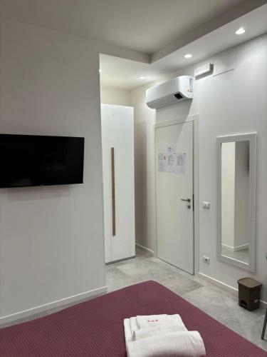 a bathroom with a tv on the wall and a mirror at Casa Marel in Lido di Ostia