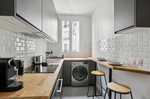 een keuken met een wasmachine en droger op een aanrecht bij 667 Suite Clement - Apartment near Paris in Vincennes