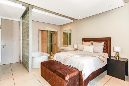 a bedroom with a large bed and a bath tub and a bath tub at Old House Lane Melrose Boulevard in Johannesburg
