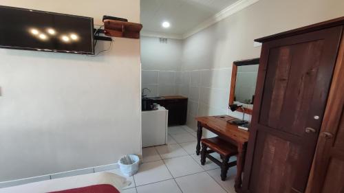 a bathroom with a sink and a mirror and a desk at Bird's Nest Guest House in Keetmanshoop