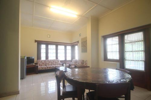 a room with a table and chairs and a living room at Hotel Villa Rawa Pening Pratama by Aparian in Bandungan