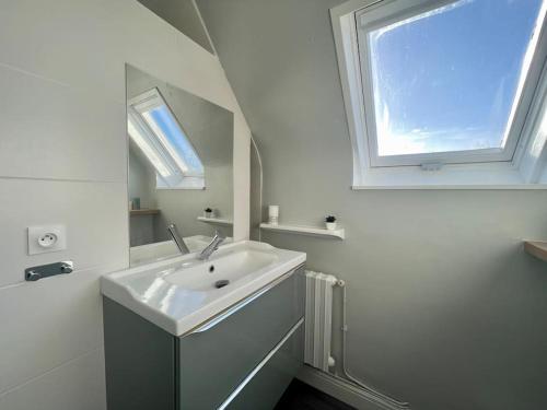 a white bathroom with a sink and a window at Horizon Vert by Melrose in Asnelles