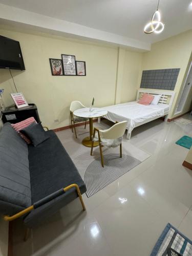 uma sala de estar com um sofá e uma mesa em Studio Guest Suite Near The New EVRMC Hospital & San Juanico Bridge Tacloban City, Leyte, Philippines em Tacloban