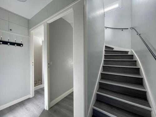 a staircase in a home with white walls and a stair case at Horizon Vert by Melrose in Asnelles