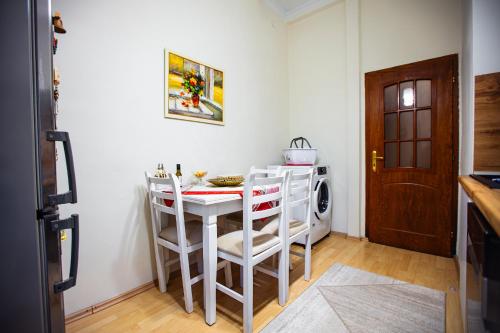a kitchen with a white table and chairs and a door at Tirana Center Apartment - Zogu I Boulevard in Tirana