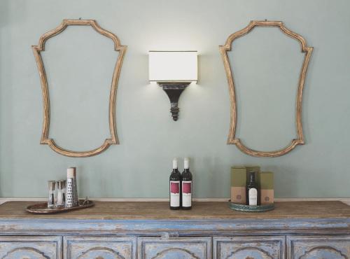 two mirrors on a dresser with wine bottles on it at Officina del Sole in Montegiorgio
