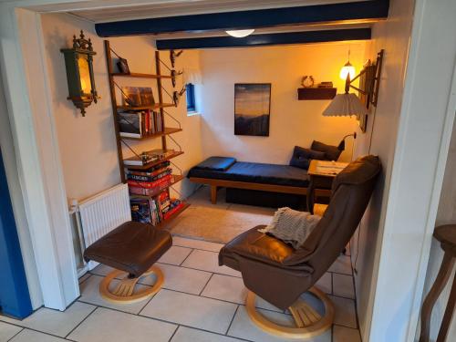 a living room with a chair and a couch at Rødsten Gæstegård in Ulfborg