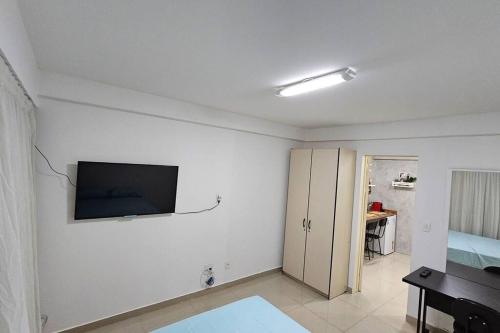 uma sala de estar com uma televisão de ecrã plano na parede em Conforto e Localização Perfeita em Brasília