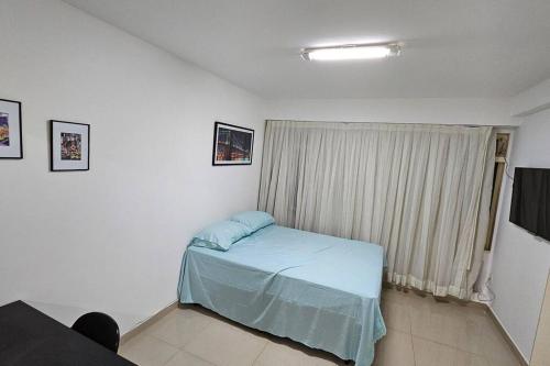 a bedroom with a bed in a room with a window at Conforto e Localização Perfeita in Brasilia
