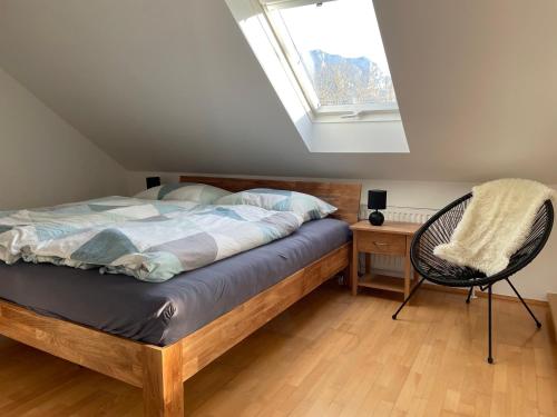 una camera da letto con un letto, una sedia e una finestra di Ferienwohnung - Toscanapark a Gmunden