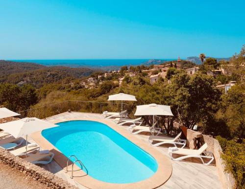una piscina con tumbonas y sombrillas en Sa Garrigueta FH, stunning views, en Galilea