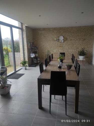 une salle à manger avec une longue table en bois et des chaises dans l'établissement Flore des Marais, à Vix