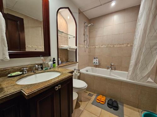 杜拜的住宿－PALACE DOWNTOWN APARTMENT，浴室配有盥洗盆、卫生间和浴缸。