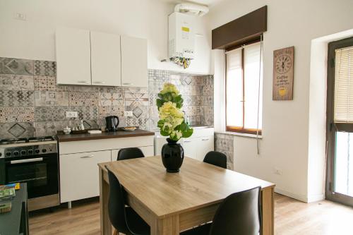 a kitchen with a wooden table with a vase of flowers on it at Alla Fiera apartment in Bergamo