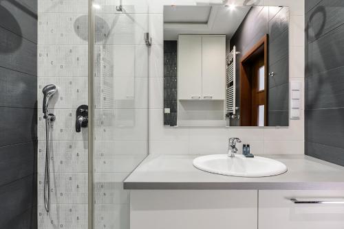 W łazience znajduje się umywalka i prysznic. w obiekcie ShortStayPoland Aleja Rzeczypospolitej (B157) w Warszawie