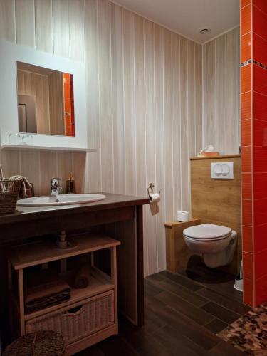 La salle de bains est pourvue d'un lavabo et de toilettes. dans l'établissement UNE AUTRE MAISON Chambres d'hôtes, à Pupillin