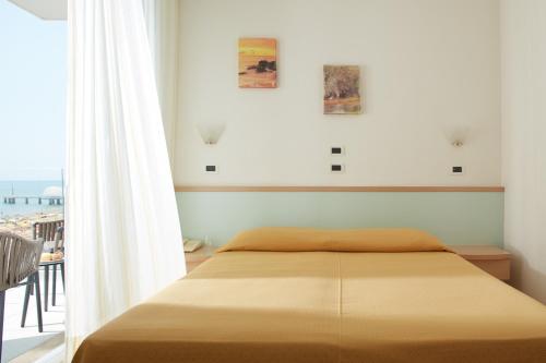 リニャーノ・サッビアドーロにあるHotel Pelikanのベッドルーム1室(ベッド1台付)が備わります。