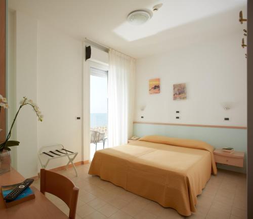 1 dormitorio con cama y ventana grande en Hotel Pelikan, en Lignano Sabbiadoro