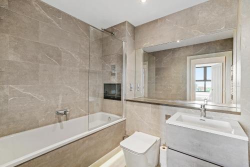 a bathroom with a tub and a toilet and a sink at Retreat: Seaside Bliss In Ramsgate in Kent