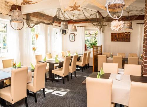 Gasthof zu den Linden 61225 في Moormerland: غرفة طعام بها طاولات وكراسي وثريات