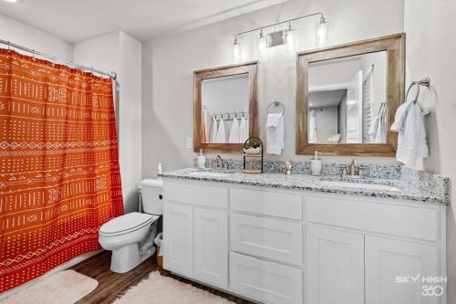 a bathroom with a sink and a toilet and a mirror at NEW! Boho Bungalow in Bella Vista