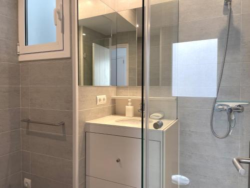 bagno con doccia, lavandino e specchio di MARQUINA - Apartamento con fantásticas vistas al mar a Cadaqués