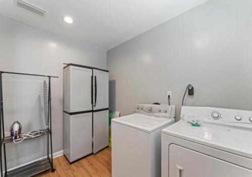 a white kitchen with a washer and a refrigerator at Delightful 4 Bedroom Luxury House In Jacksonville in Jacksonville