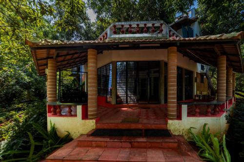 a house with a balcony on top of it at Aurovidya Retreat in Kottakupam