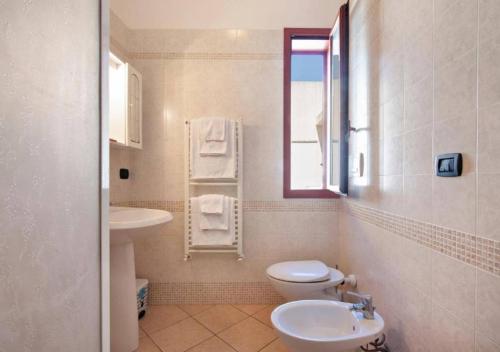 a bathroom with a toilet and a sink and a window at Armonia Machiavelli House Gallipoli in Gallipoli