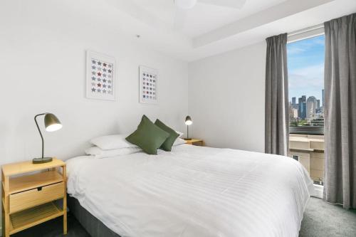 a bedroom with a white bed and a window at East Melb 2bed parking pet friendly in Melbourne