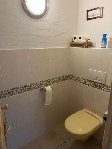 a bathroom with a toilet and a roll of toilet paper at Les Chênes Verts in Le Grand Vieil