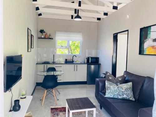 a living room with a couch and a table at Cozy Garden Facing Guest Suite -(Back up power) in Midrand