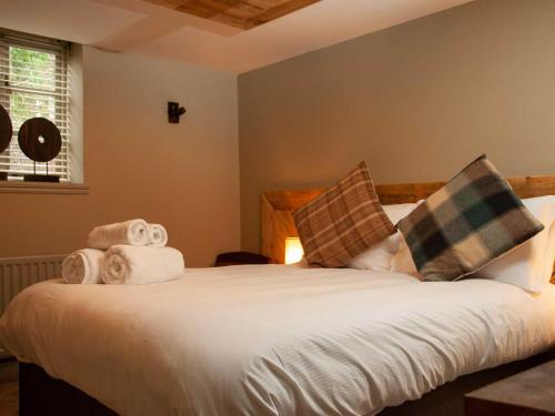 1 dormitorio con 1 cama con toallas en The Wiremill en Felbridge