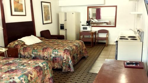 Executive Inn & Suites في ليكفيو: غرفة فندقية بسريرين وطاولة