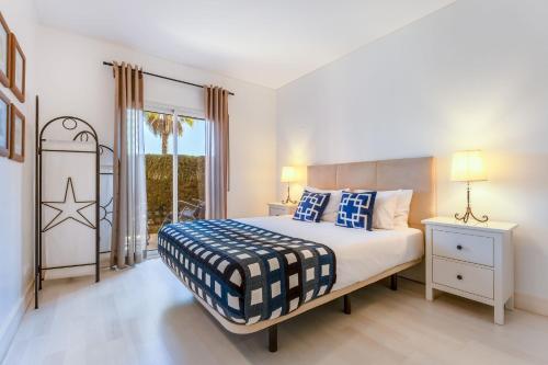 a bedroom with a bed with blue and white pillows at Serene Ocean 1 BDR Apartment With Patio by LovelyStay in Portimão
