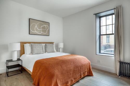 a white bedroom with a bed and a window at Brooklyn Heights 2br w elevator wd NYC-1066 in Brooklyn