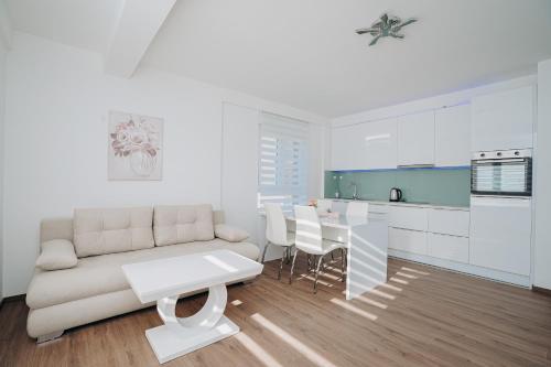 a white living room with a couch and a table at Apartment DIANA in Kladovo