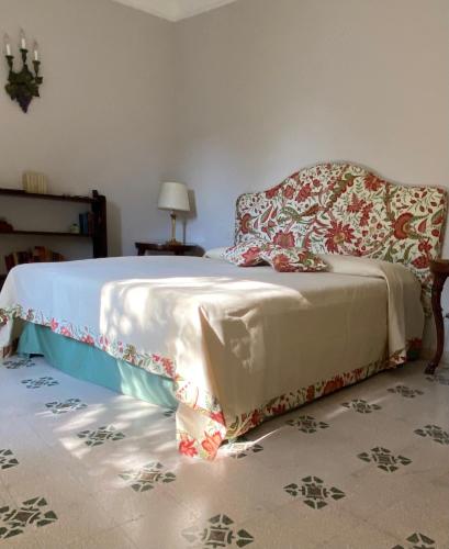 a bedroom with a bed with a blanket and a chair at Burlamacchi Villas in Bagni di Lucca