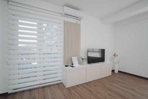 a living room with a television and a white wall at Apartment DIANA in Kladovo