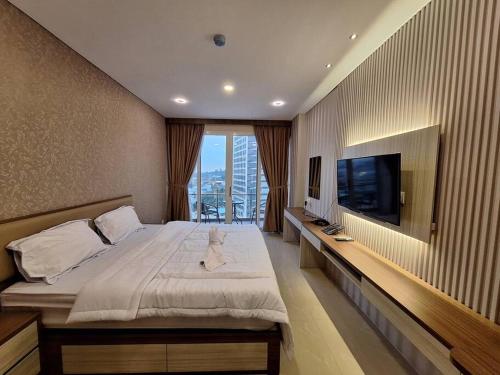 - une chambre avec un grand lit et une télévision à écran plat dans l'établissement Nagoya Thamrin City Tower A @ Fave Hotel Nagoya, à Nagoya