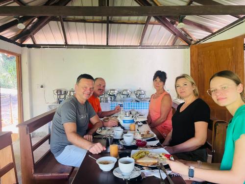 a group of people sitting at a table eating food at White Villa Kitulgala in Kitulgala