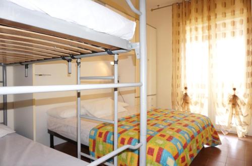 ein Schlafzimmer mit zwei Etagenbetten und einem Fenster in der Unterkunft A few steps from the beach in Porto Santa Margherita