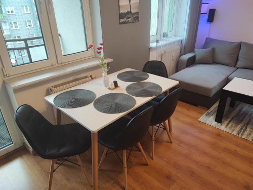 a table in a living room with chairs and a couch at Apartament Mickiewicza w centrum Augustowa in Augustów