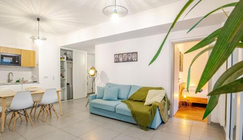 un salon avec un canapé bleu et une table dans l'établissement Reflet du Veyrier 4 étoiles - Proche lac & Vieille Ville, Garage privé, Secteur recherché, à Annecy