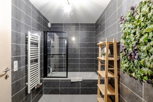 a bathroom with a shower with black tiles at Reflet du Veyrier 4 étoiles - Proche lac & Vieille Ville, Garage privé, Secteur recherché in Annecy
