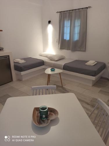 a room with two beds and a table and chairs at Vlastos 2 in Mylopotas
