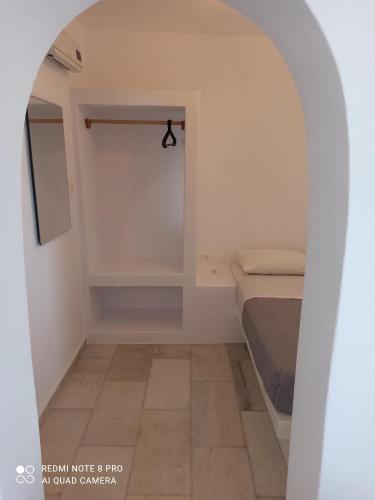 a small bedroom with a bed and a walk in closet at Vlastos 2 in Mylopotas