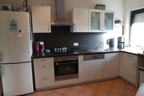 uma cozinha com um frigorífico e um fogão forno superior em Ferienwohnung Rübenach em Koblenz